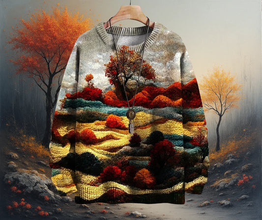 Sweater with a landscape design of trees and fields on a hanger against a natural background