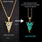 Two arrowhead pendants with gold and aqua blue light on a black background