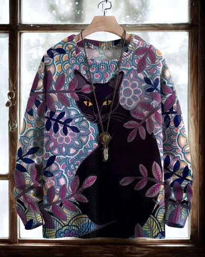 Black cat with glowing eyes on a purple and blue floral patterned 3D sweater