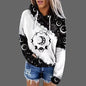 White hoodie with black moon and star pattern worn by a person on a gray background