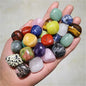 Hand holding a variety of colorful natural tumbled stones for feng shui and home decor