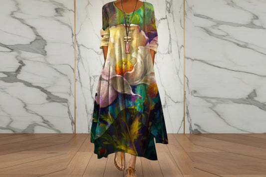 Full-length view of a woman in a green and purple abstract floral maxi dress with an uneven hem.