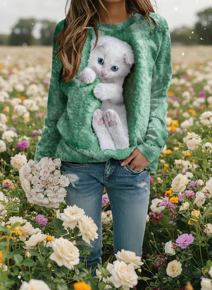 Lifestyle photo of woman in olive green cat-themed sweatshirt with 3D kitten design, standing in flower field