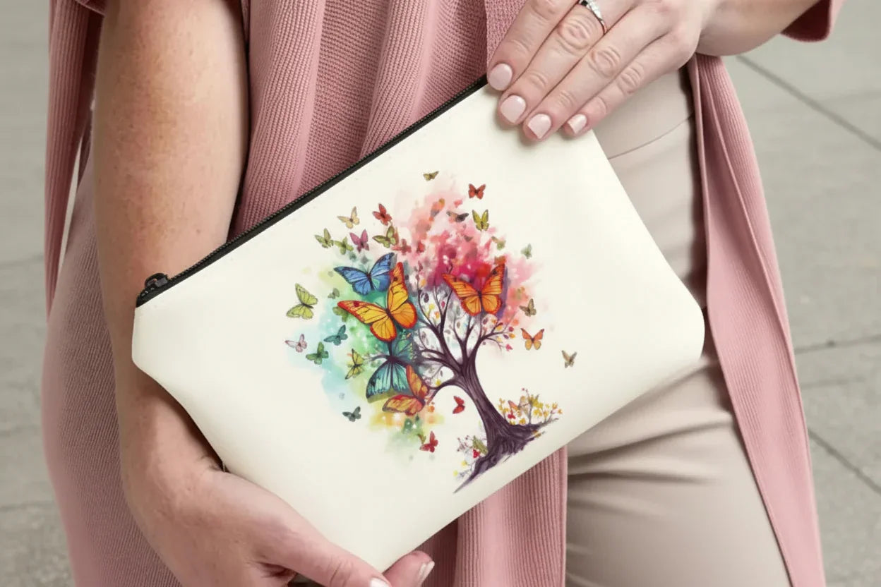 Person holding a pouch with a colourful tree and butterfly design.