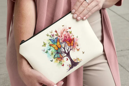 Person holding a pouch with a colourful tree and butterfly design.