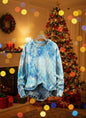Tie-dye blue and white 3D sweater in front of lit Christmas tree