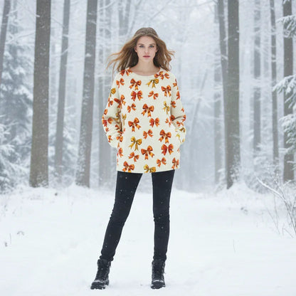 Cream-coloured autumnal sweater with gold and orange bow prints, pictured in a bright winter wood setting.