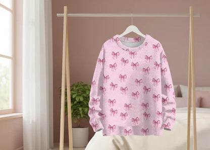 Pale pink coquette-style bow sweater on a minimal clothing stand.