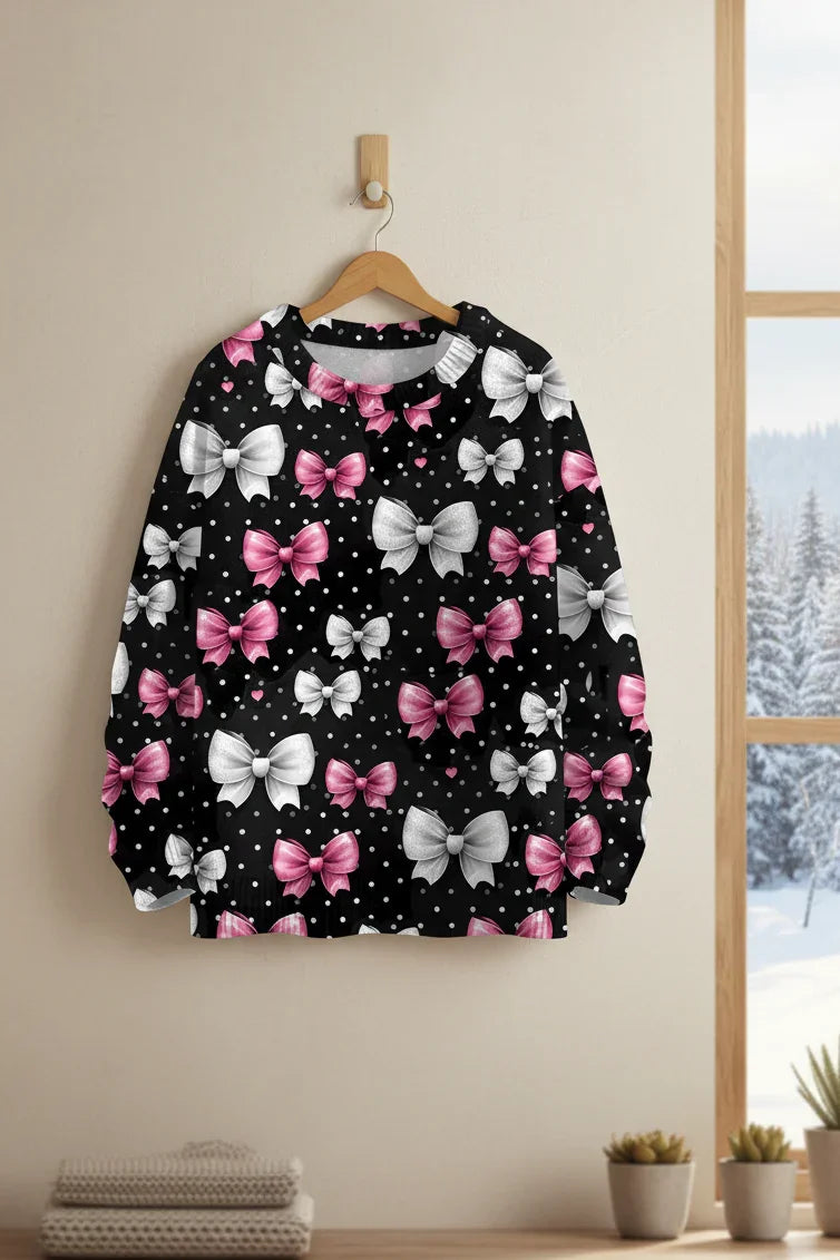 Black sweatshirt with white and pink bow prints and starry polka dot details.