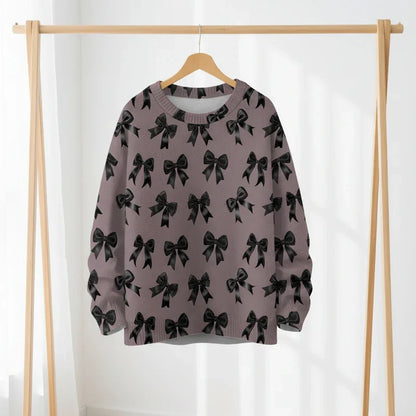 Dark dusty-rose pullover with black bows displayed on a wooden rack.
