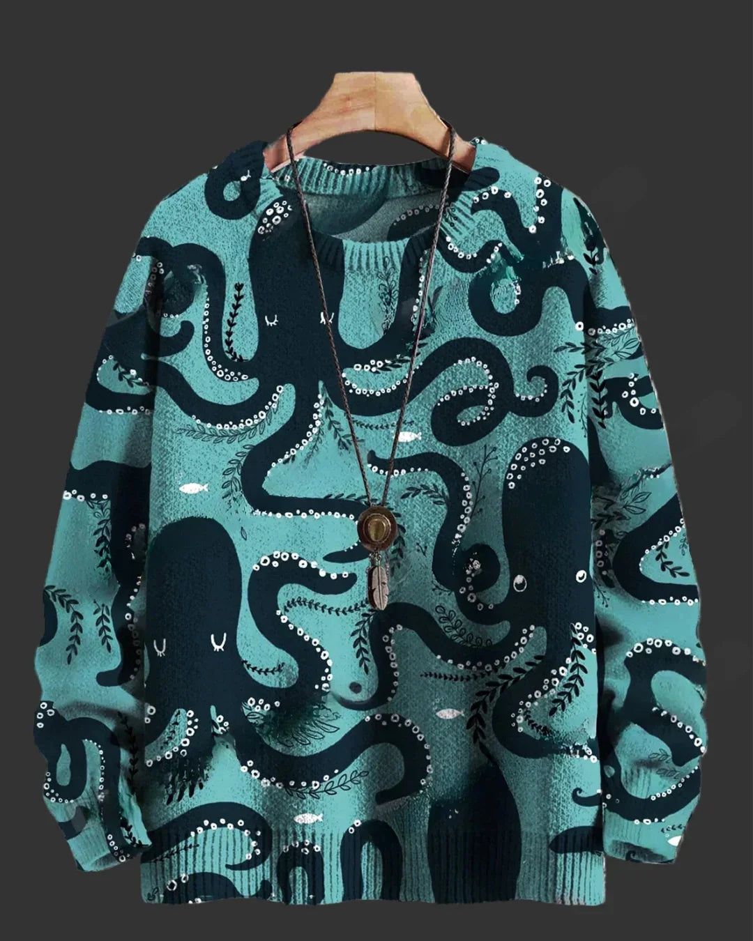 Teal sweater with black octopus pattern on a hanger against a dark background