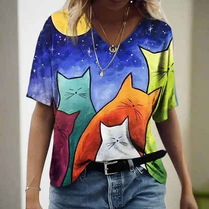 Galaxy-themed t-shirt with three stylized cats (teal, orange, white) on a starry background.