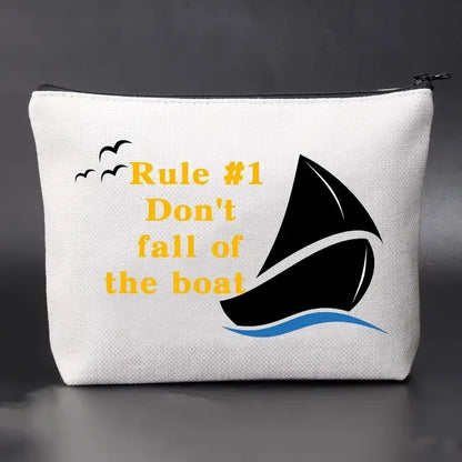 White pouch with sailboat design and text on a dark background