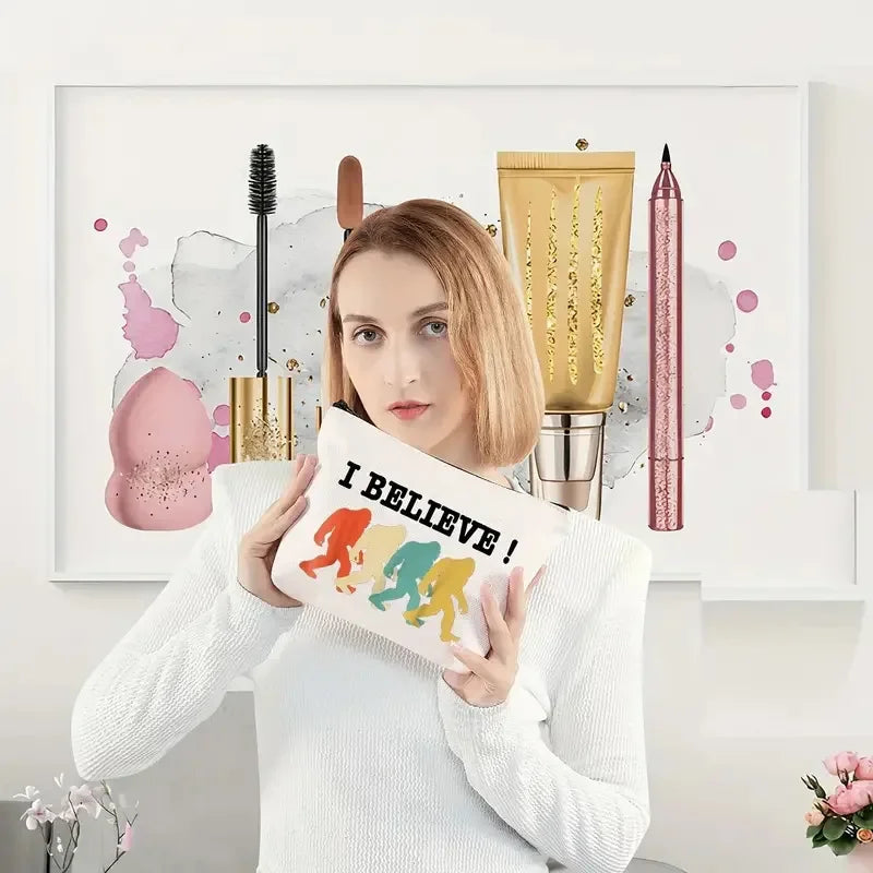 Woman holding a pillow with 'I Believe!' and colourful silhouette design in front of a decorative wall with makeup items.