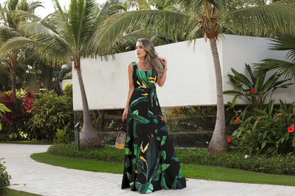 Woman wearing a sleeveless dress with tropical leaf pattern outdoors.