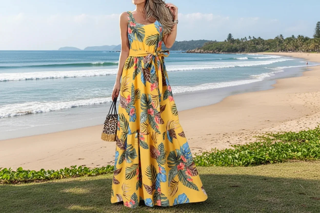 Woman wearing a yellow floral dress standing outdoors with palm trees in the background