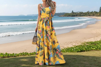 Woman wearing a yellow floral dress standing outdoors with palm trees in the background
