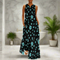 Chic sleeveless black maxi dress with scattered aqua blue floral patterns, modeled in a stylish modern bathroom