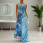Sleeveless navy blue maxi dress with white floral print, worn by a woman walking down a cobblestone street