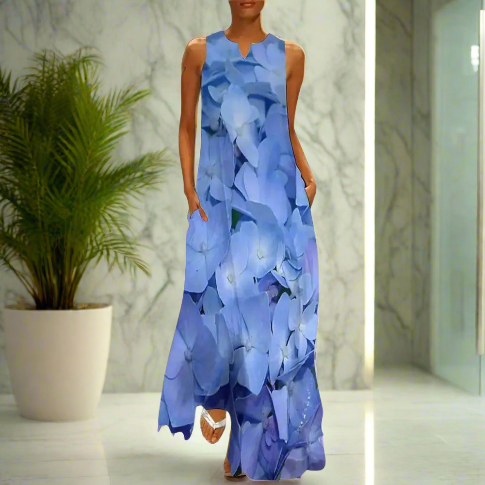 Elegant sleeveless maxi dress featuring a soft blue hydrangea flower print, styled in a marble-finished interior