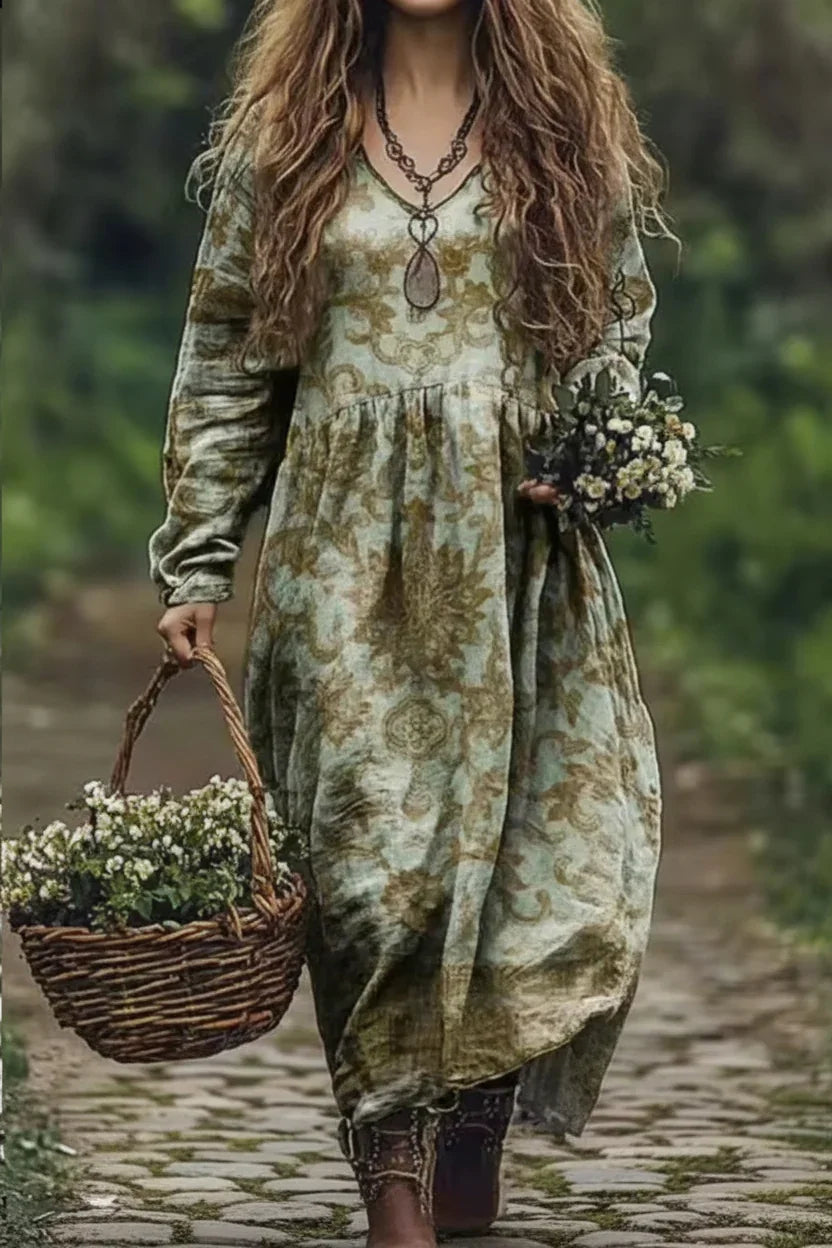 Person wearing a long, patterned dress holding flowers and a basket in a natural setting.