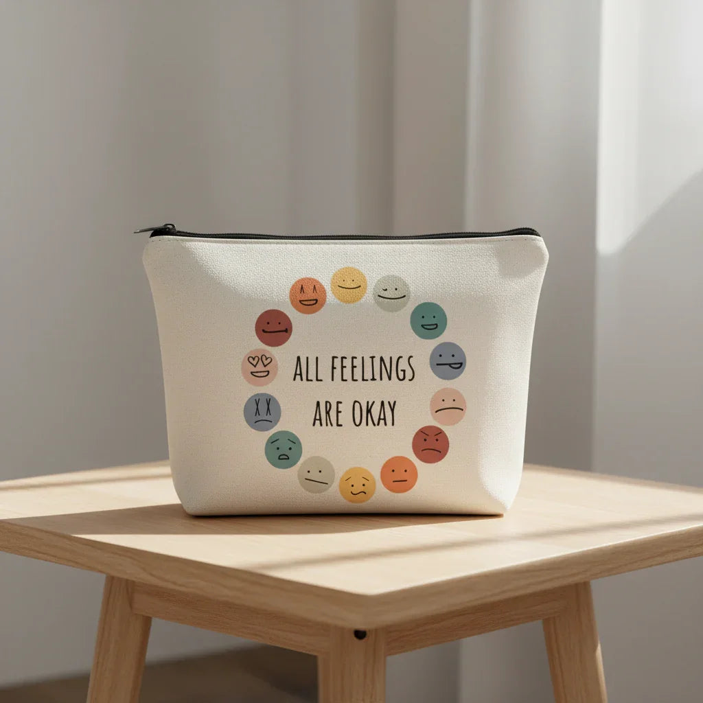 Canvas pouch with smiley face illustrations and 'All feelings are okay' text on a white background