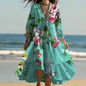 Woman wearing a teal floral print V-neck long sleeve dress with irregular lotus leaf hem, standing on the beach during sunset.