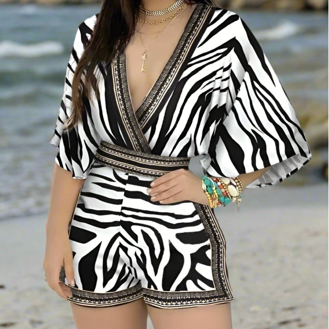 Woman in a zebra floral romper with ruffle sleeves and shorts, standing 