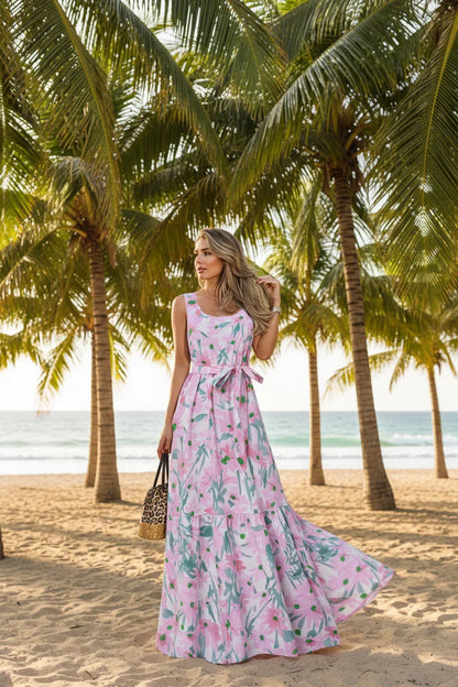 Woman wearing a pink floral dress standing outdoors with palm trees in the background